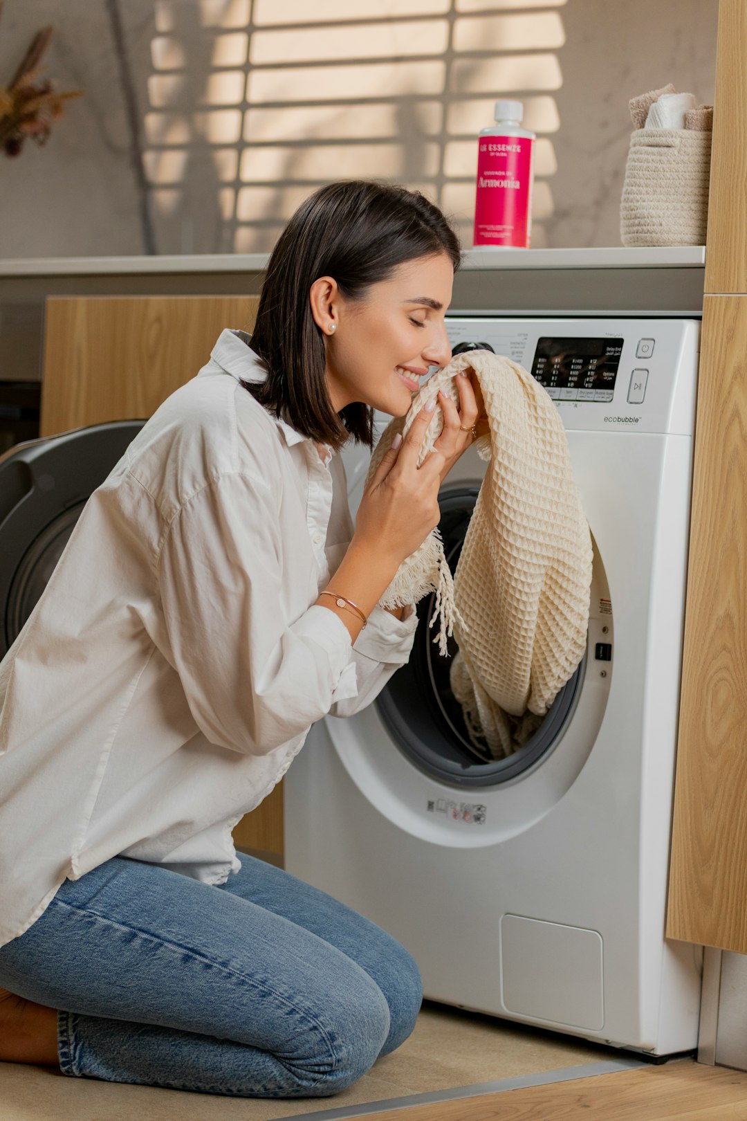 a-woman-sitting-on-the-floor-in-front-of-a-washing-machine-xgqztxaq7py